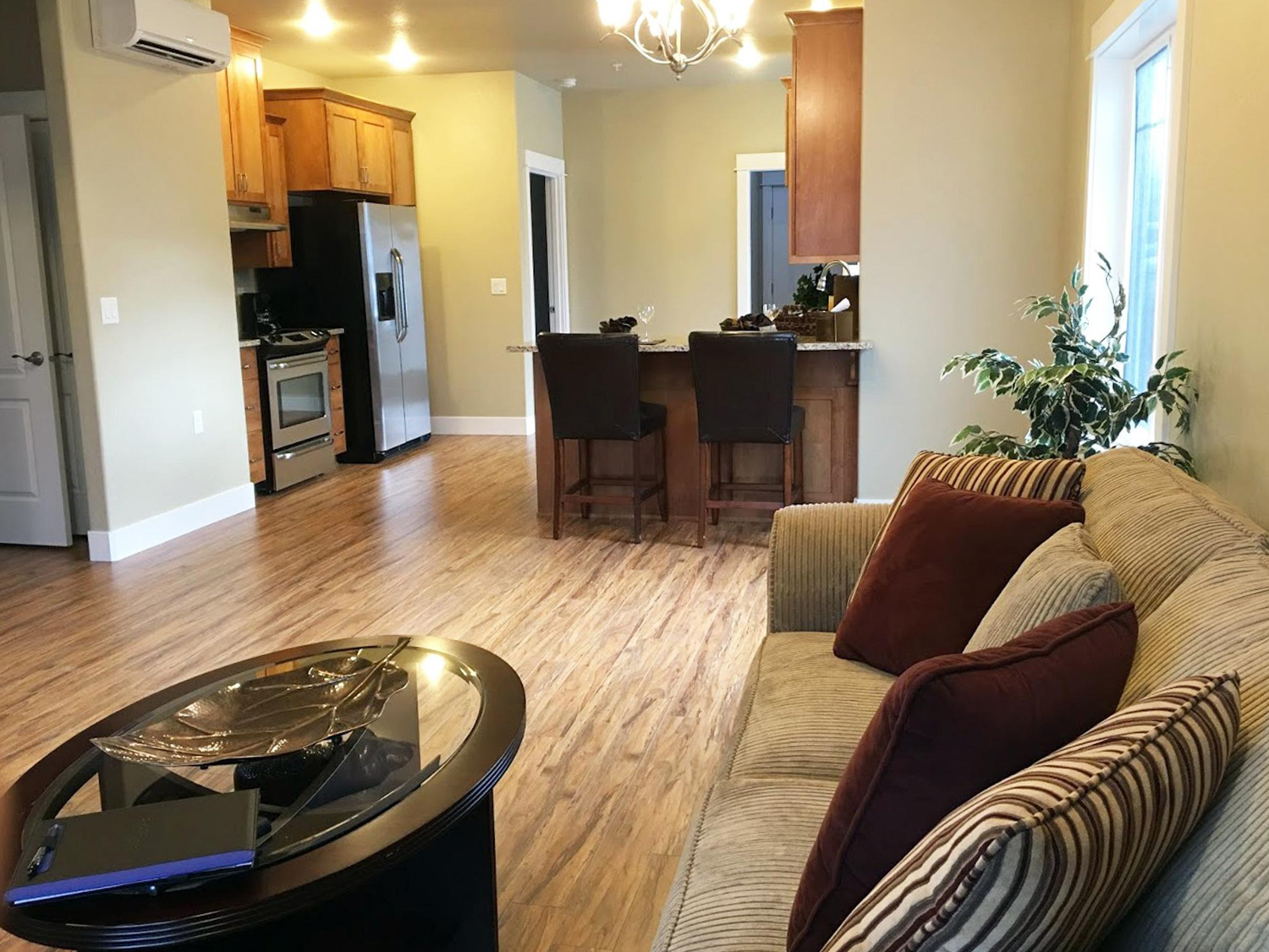 Open living space with a granite kitchen island, bookshelves, and a flat-screen TV | Senior Apartment Homes 